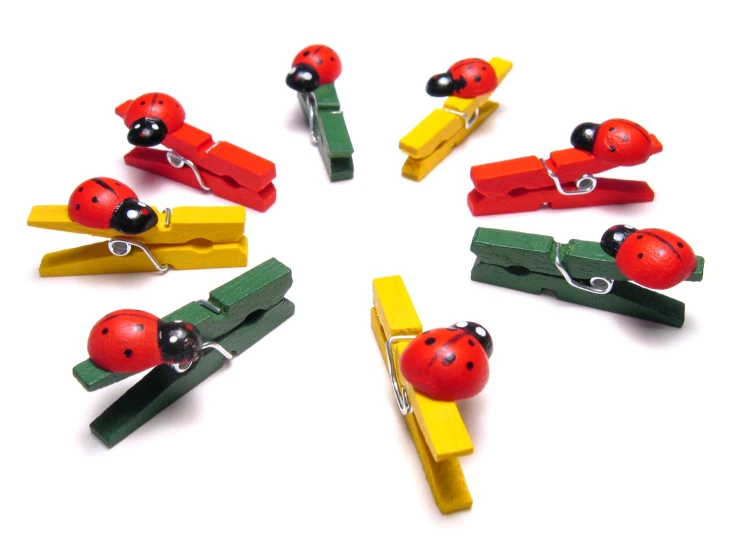 several pieces of paper with ladybug wooden pegs attached to them