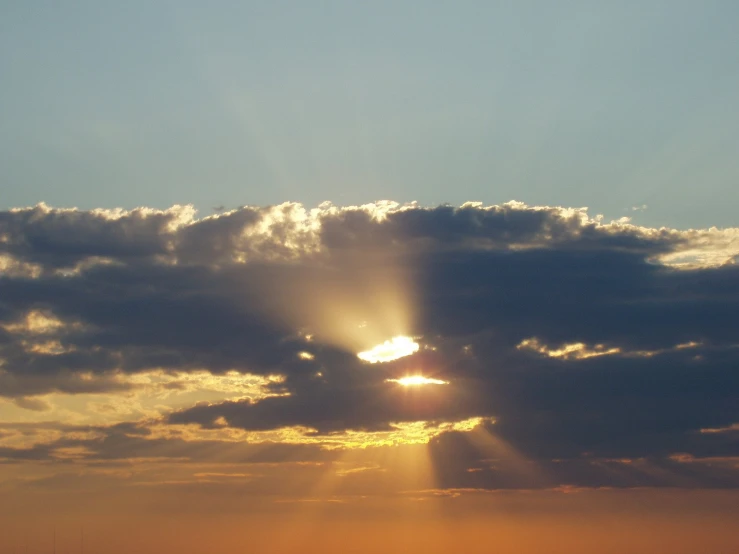 the sun is peaking through clouds over the ocean