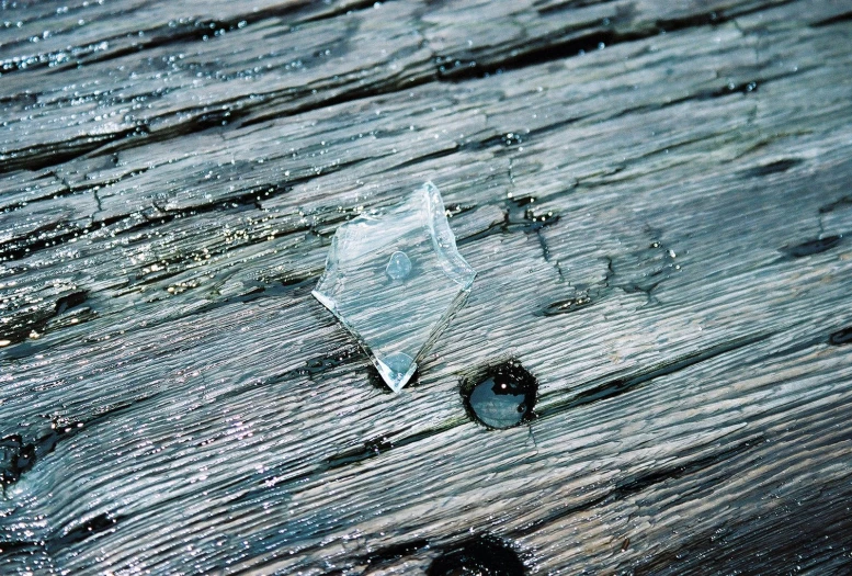 a window glass sitting on top of a wooden plank