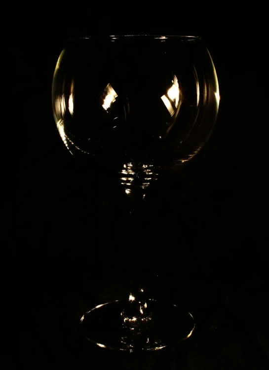 a glass in the dark with some light coming from above