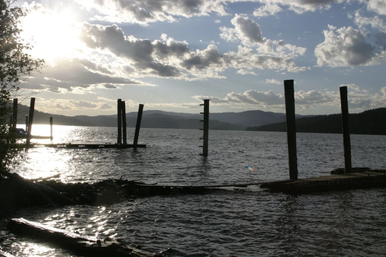 a boat moored on a lake with it's poles sticking out from the water