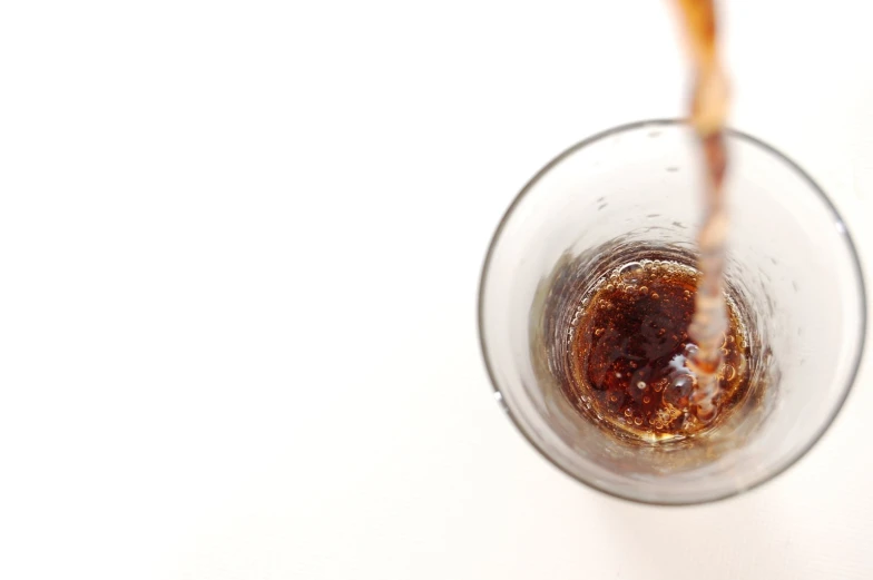 a glass full of a liquid that is being poured into it