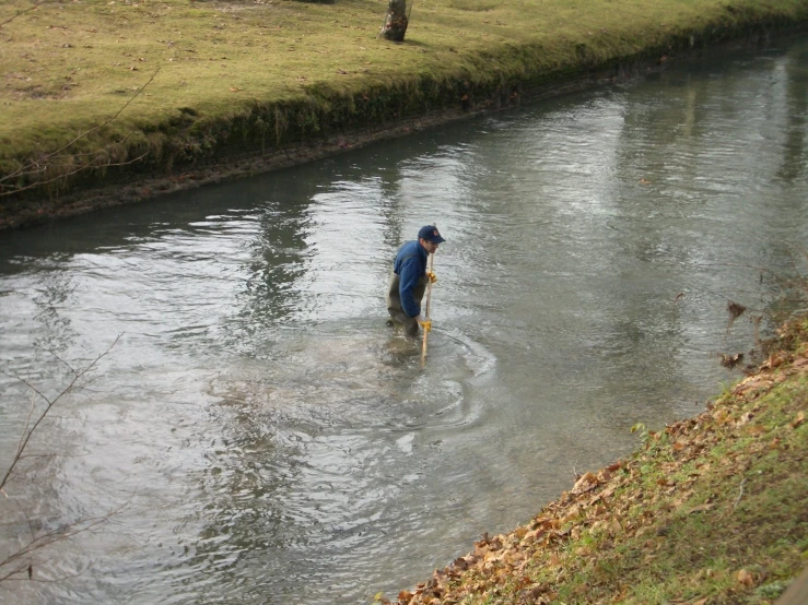 a man wades through a river that stretches from the city side