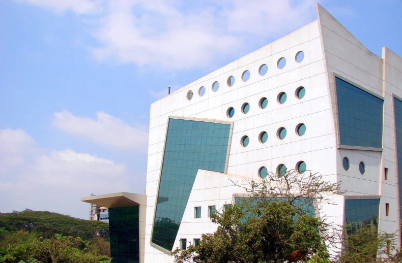 a tall white building that has round windows and two stories