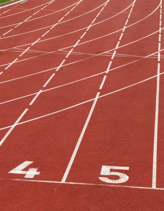 red running lanes in an empty stadium with white numbers