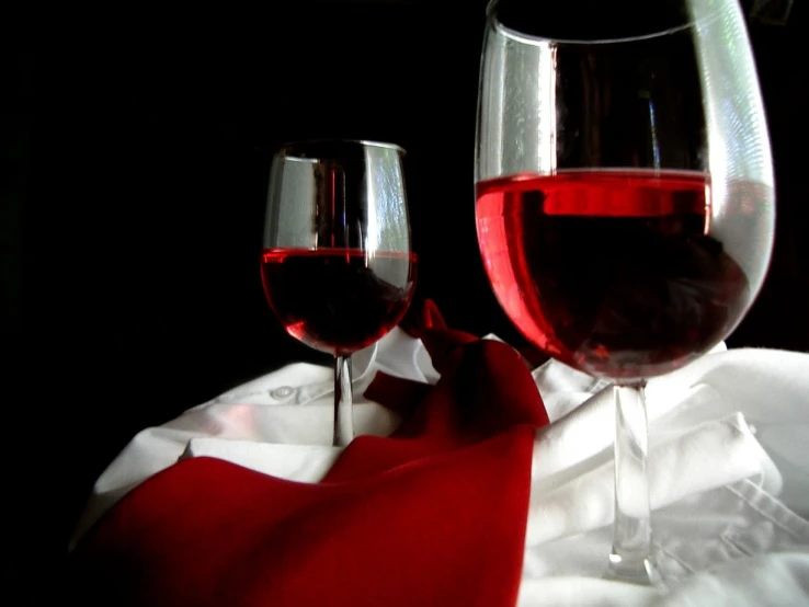 two glasses filled with wine on top of a table