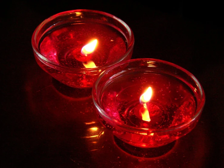 two candles that are lit in red candles