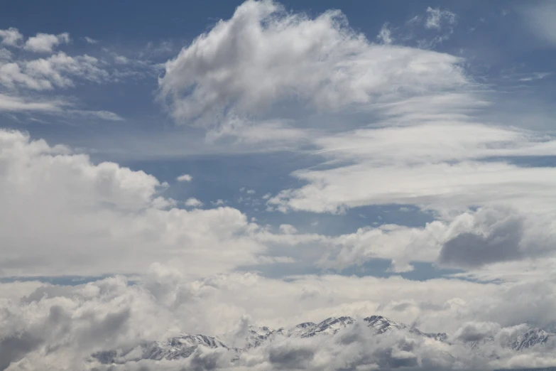 an airplane is flying in front of some clouds