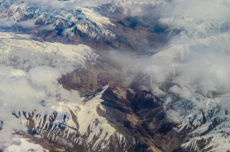 there are snow and clouds on the mountains