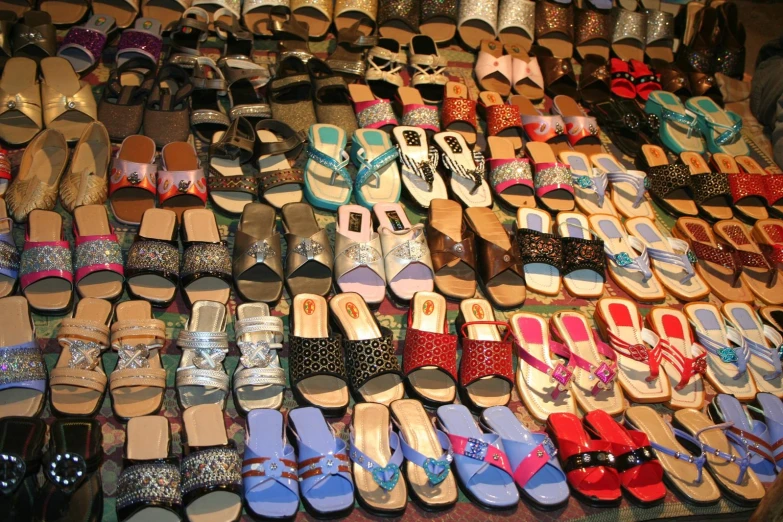 several rows of shoes are on display at a market