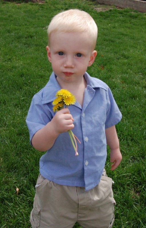 the little boy smiles at the camera while holding a toothbrush