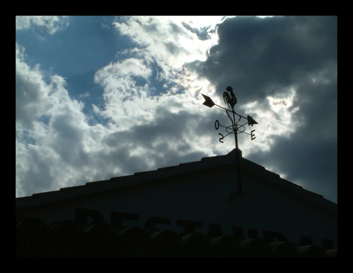 the weather vane on top of the roof is high