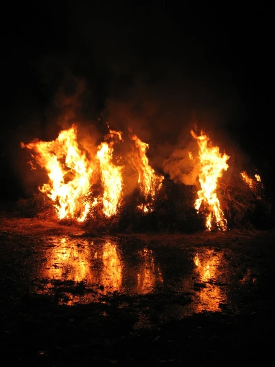 several fire hydrants with flames blazing over the water