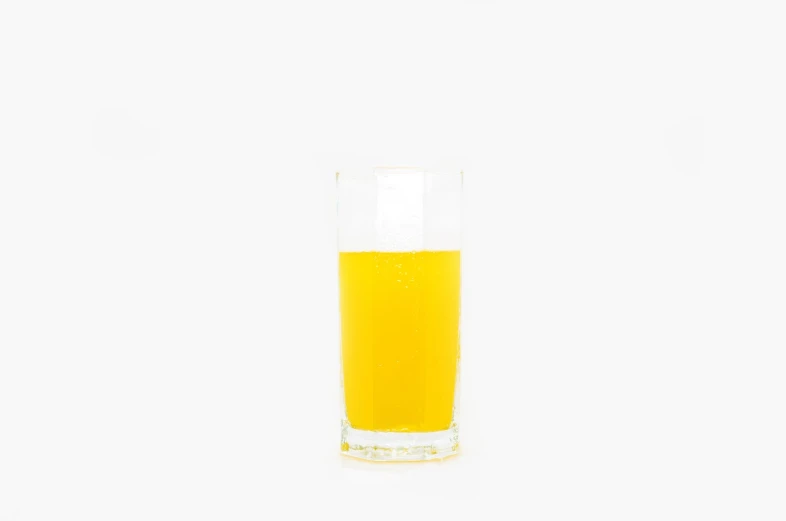 a half filled glass sits on the white surface