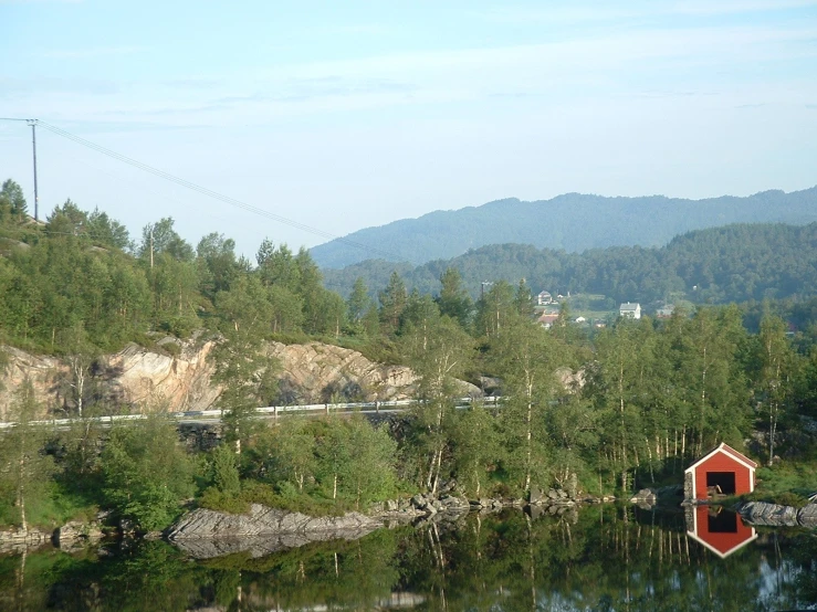 a lake with a house in it with a train on a track in the distance