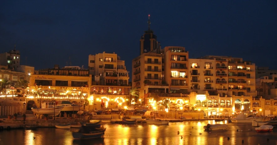 buildings on the water next to a city at night