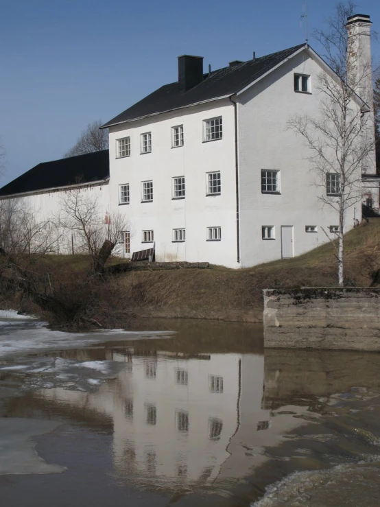 a building with many windows next to a body of water