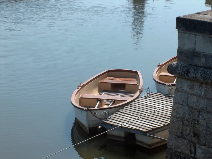 two boats that are sitting in some water