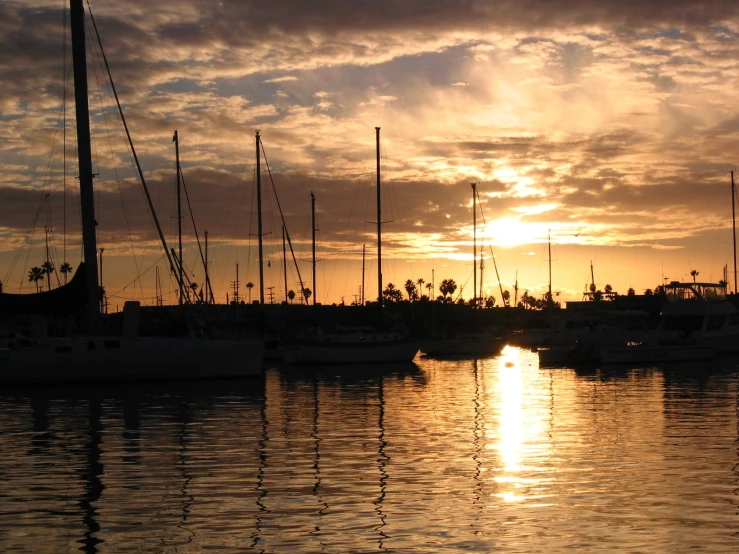 there are many boats on the water at sunset