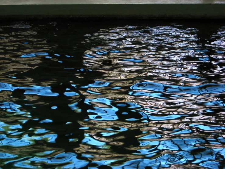 water with blue, green and yellow reflections and patterns on it