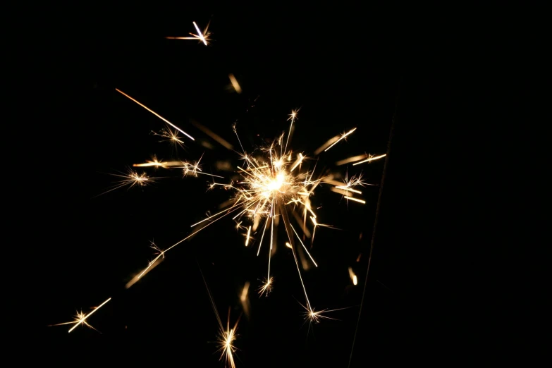 a sparkler lit up in the dark with one light and another light shining brightly