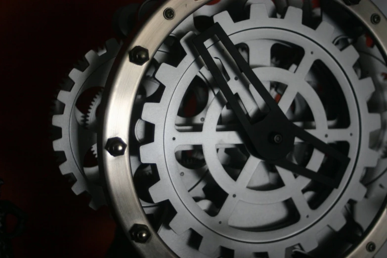 a metal clock with gears in it on a wall