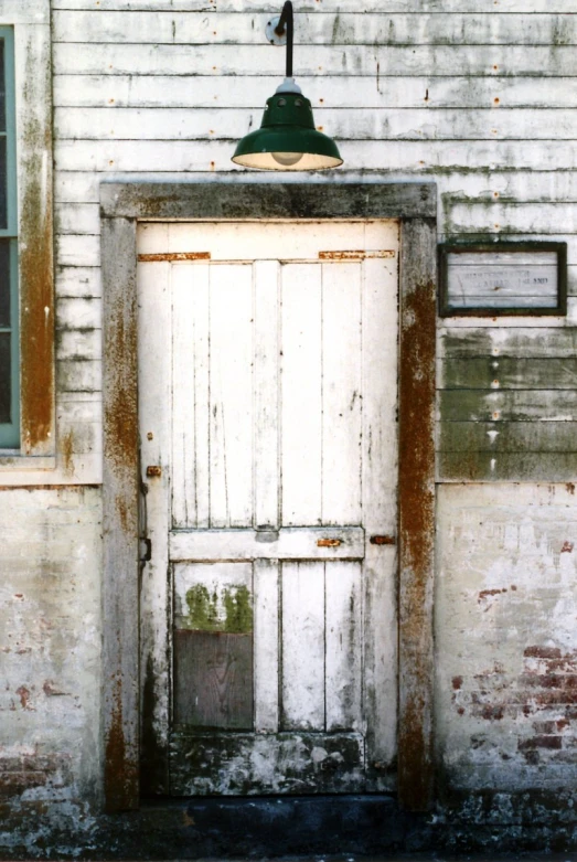 an old white house with a large wooden door