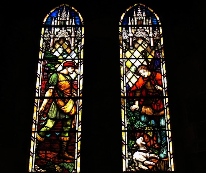 a couple of large stained glass windows with some people inside