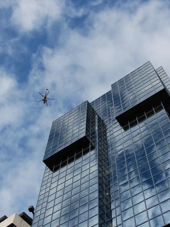 a large airplane flying near two modern buildings