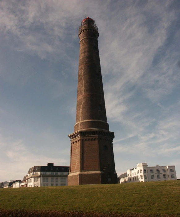 a tall lighthouse near some white buildings