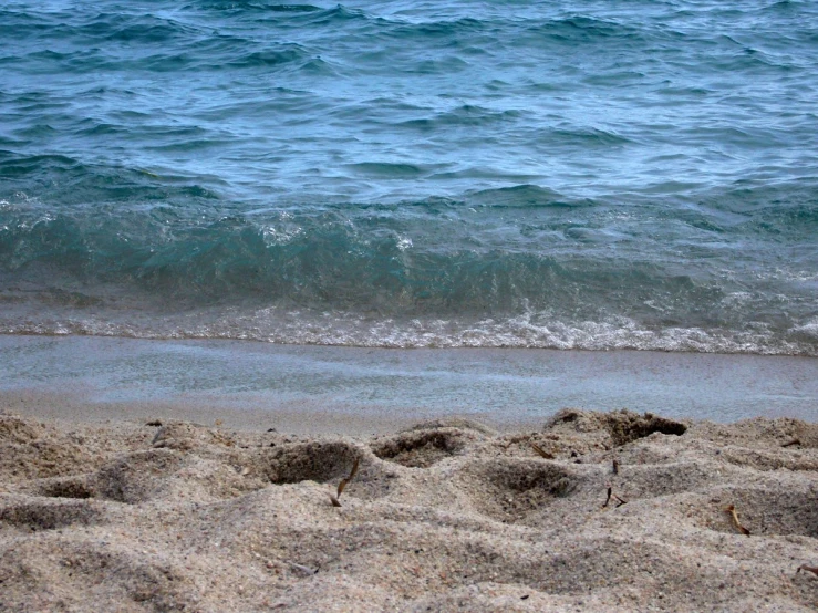 a close up of the ocean water and sand