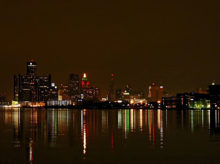 the skyline of a city sits over a still bay