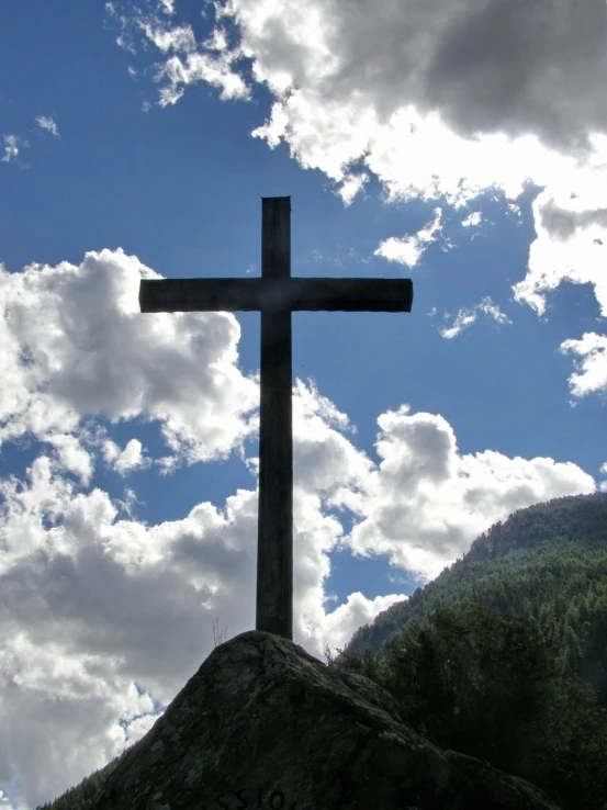 the cross is shown in front of a rocky landscape