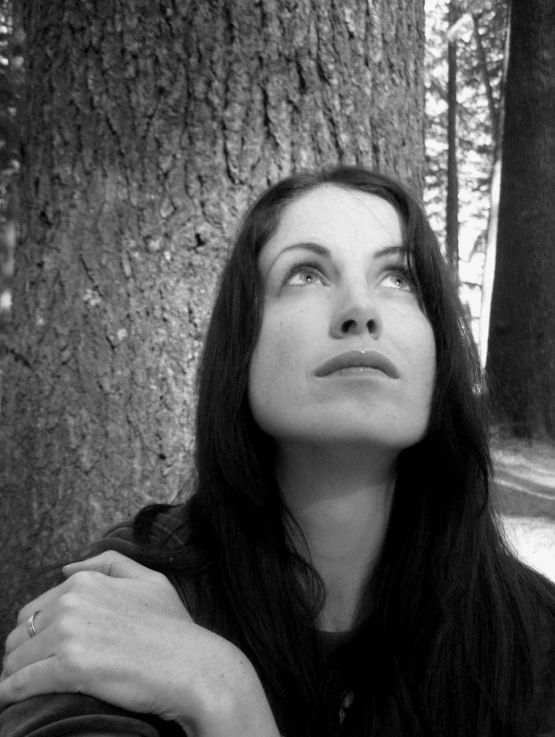 black and white pograph of a woman looking up at a tree