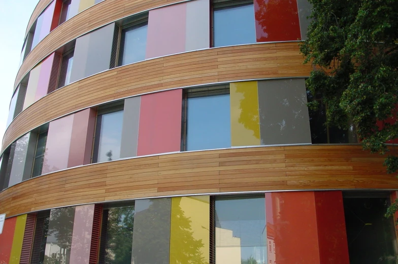 a multicolored building with a tree in front