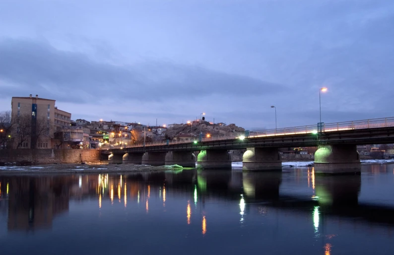 a large bridge over a small lake at night