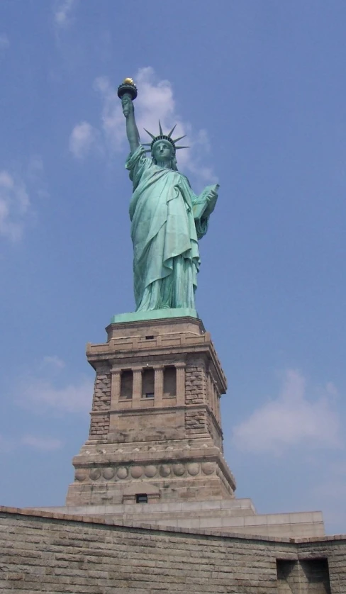 statue of liberty is pictured against the blue sky