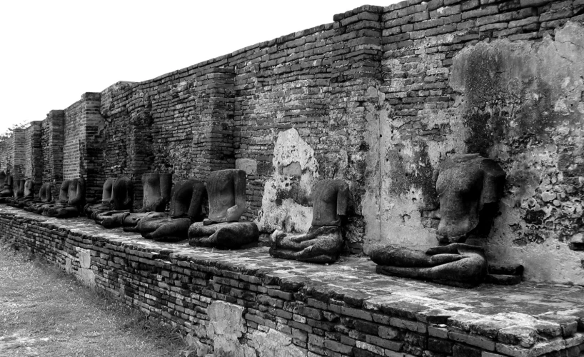 old brick pillars and heads of sheep in an area near the water