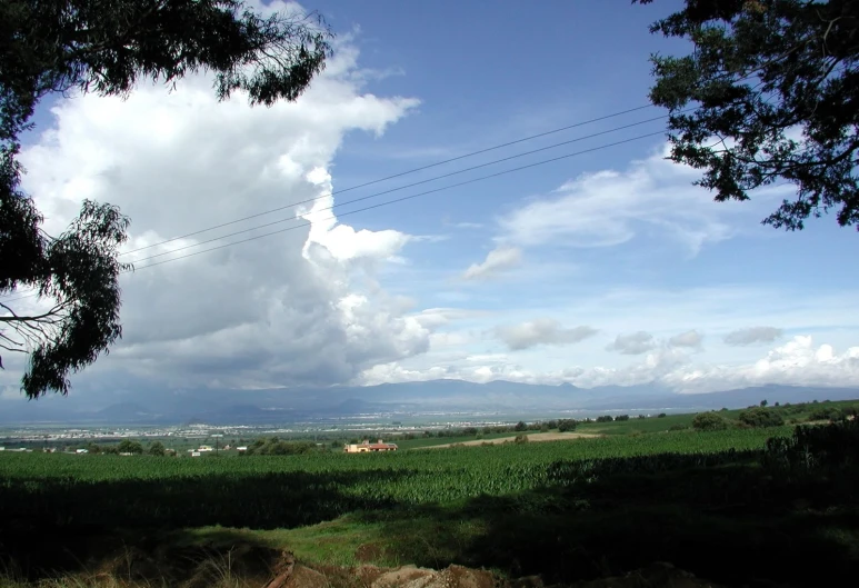 a view of the sky over a hill and fields