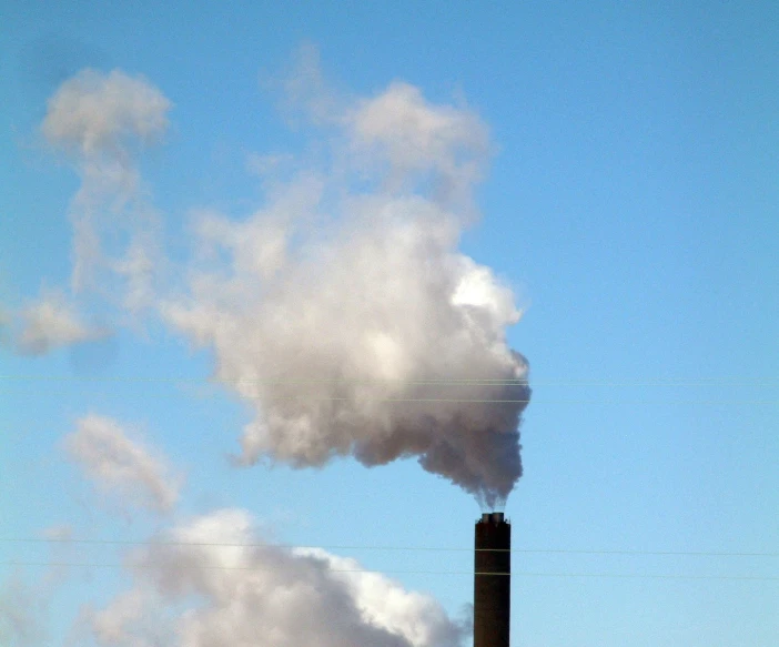 a smoke plume from a pipe emits from the sky