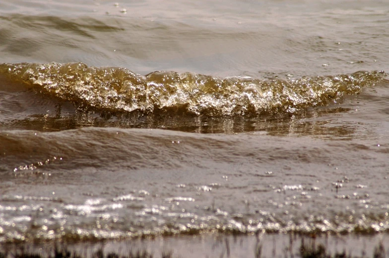 there are waves coming in the water in front of a wave