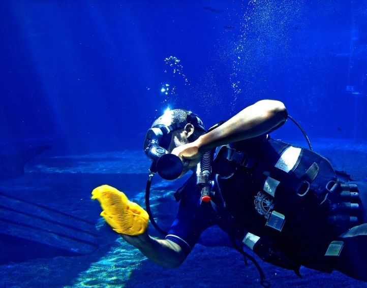 a person swimming under the ocean wearing diving gear