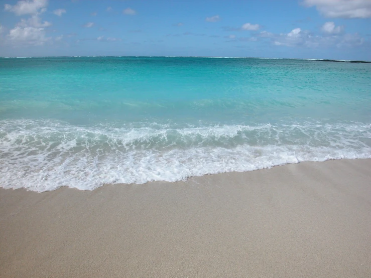 waves are breaking against the sand at the beach