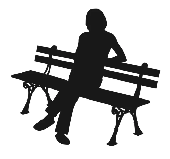 a person sitting on a bench with their hands on their knees