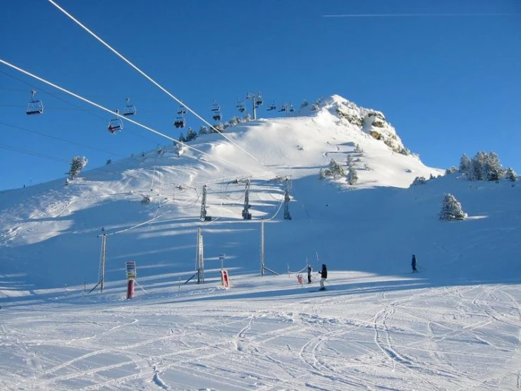 a ski lift and chairlifts going up the side of a snowy mountain