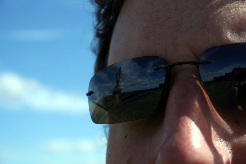 the reflection of a person with long hair and a pair of sunglasses