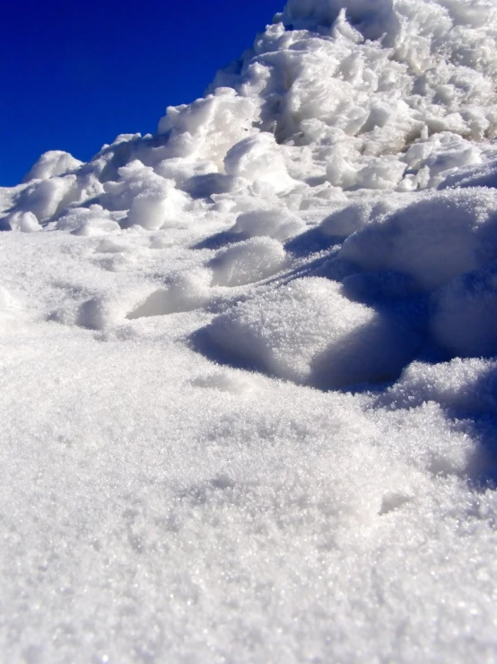 the snow is covering the mountain side and it looks like a trail