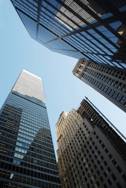 a view from ground looking up at some very tall buildings