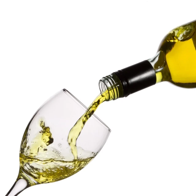 a wine bottle pouring white wine into a glass