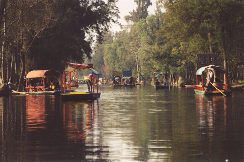 the boats are traveling on the river as people walk by